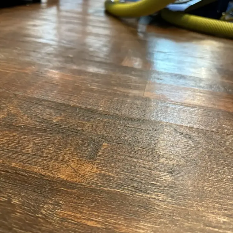 Wet hardwood floor with a drying hose after a water leak in Flower Mound