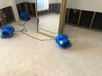 Air movers drying a room after a flood cut along the lower walls
