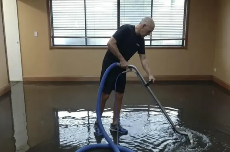 Extraction wand pulling standing water off a flooded floor in a Flower Mound home
